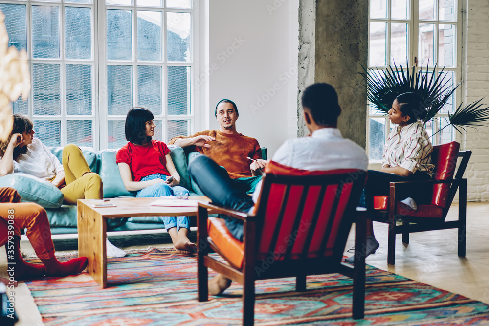 Wall mural group of delighted multiethnic friends chatting at home