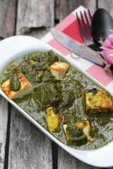 A bowl of Palak Paneer made of Paneer cheese dipped in mildly spiced Spinach gravy.