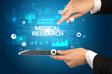 Close-up of a touchscreen with MEDICAL RESEARCH inscription, medical concept
