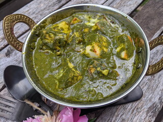 A bowl of Palak Paneer made of Paneer cheese dipped in mildly spiced Spinach gravy.