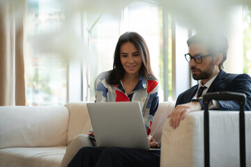 Man and woman executives looking at screen of a laptop together