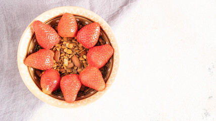 Easy breakfast of granola bowl and sun shape from strawberry. Summer berries on top of oat with honey. Sweet and healthy