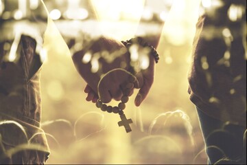 Couple praying, man and woman holding hands with beads