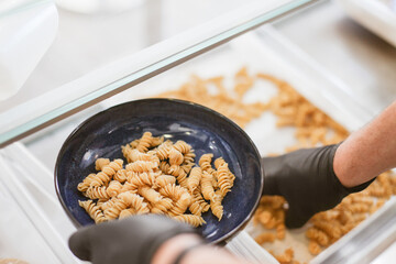 Process of putting fresh made pasta on a plate from a plate. A professional chef cook cooking pasta