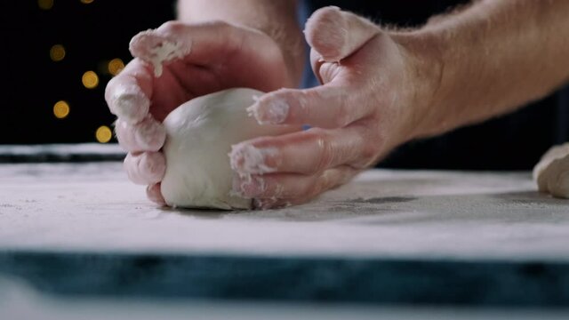 Close-up of man young chef hands making a pizza dough ball