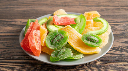 Children's colored sweet healthy food menu. Dried fruits on a plate close up. Diet dessert on a wooden table