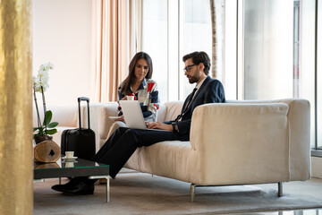 Co-workers discussing business project for cup of coffee at guest house foyer