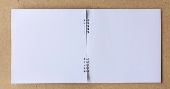 4k Stop motion book animation open white blank page for writing on wooden background.