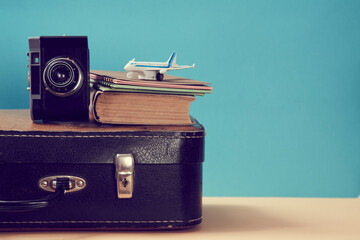 Traveler blog. Vintage travelling background. Blogging. Retro black travel case, old camera, book and model of plane