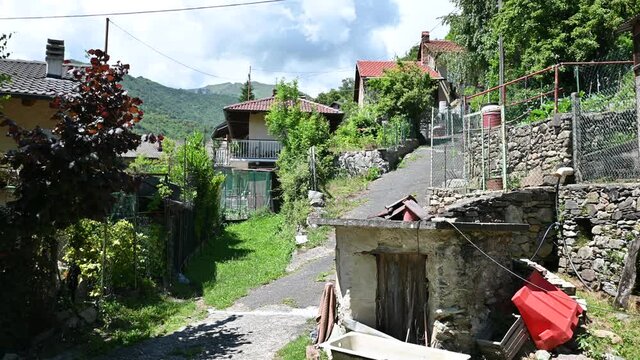 View of a half-mountain village surrounded by green nature. Tilt movement, you see the road that creeps between the houses.