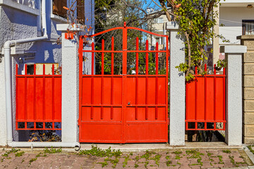 Entrance gate made of metal painted red.