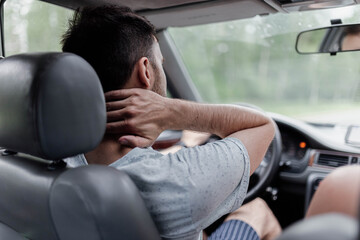 male driver  massages the neck, back and neck pain.