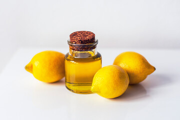 Lemon essential oil and fruits on white background.
