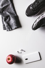 Mockup mobile cellphone with earphone and running shoes on white background. Healthy lifestyles