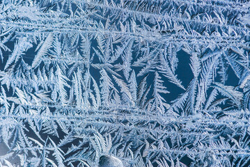 Nice frost pattern on glass in cold temperature colors for summer heat, abstract background