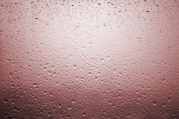 Drops of rain on a window glass with very diffuse landscape red scarlet color