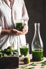 Woman takes a glass of smoothie into a glass, detox, wholesome food, vegan, eco. Body cleansing