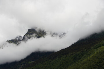 View of rising wafts of mist above the wilderness in the mountains between Chur and Bellinzona in the Swiss Alps