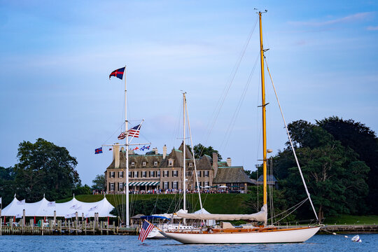 Classic wooden sailing yacht moored off a historic yacht clubhouse in Newport Harbor, Rhode Island