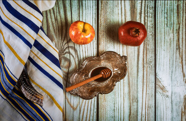 On the table in the synagogue are the symbols of Rosh Hashanah apple and pomegranate, shofar talith
