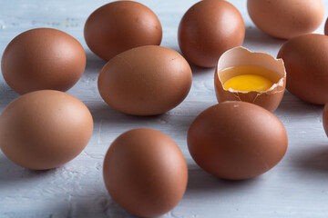 Chicken eggs broken in the middle of other eggs. Top view