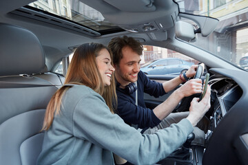 Delighted man and woman admiring images on cell phone