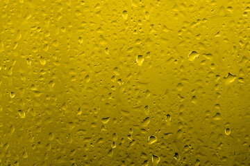 Water drops on glass with vivid medium contrast yellow color