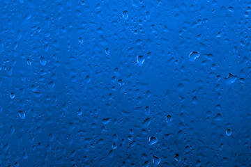 Water drops on glass with vivid medium contrast cobalt blue color