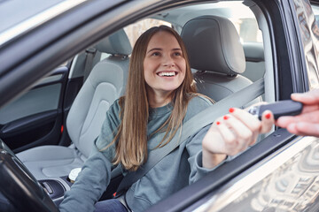 Gladsome young lady receiving car security fob