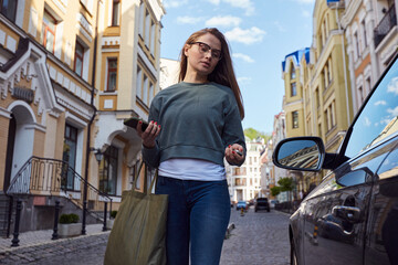 Young female opening her automobile with key fob