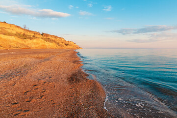 Amazing empty evening beach with footprints on the sand.