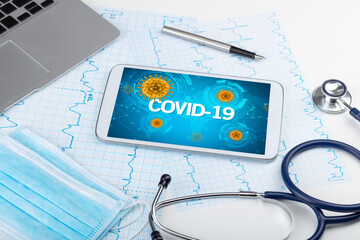 Close-up view of a tablet pc with COVID-19 inscription, microbiology concept