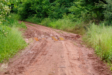 Fototapeta premium Rural Dirt Road With Puddles After Rain
