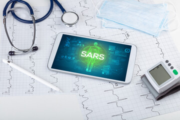 Tablet pc and doctor tools with SARS inscription, coronavirus concept