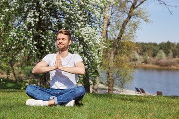 Obraz premium Restful bearded man training yoga exercises in open air