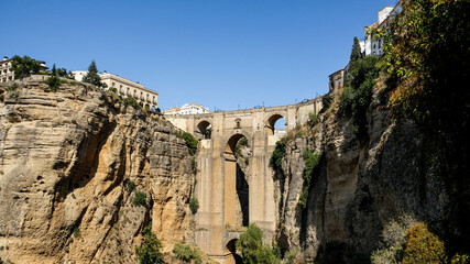 Fototapeta na wymiar Puente Nuevo famous new bridge in the heart of old village Ronda in Andalusia, Spain. Touristic landmark on a sunny day with buildings in the background. Front view captured from a viewpoint below.