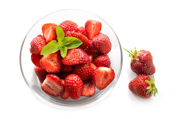 Dessert from fresh strawberries with peppermint garnish in a glass bowl, isolated with shadows on a white background, high angle view from above