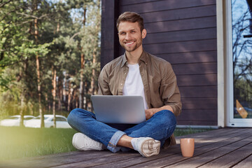 Obraz premium Handsome young man with a laptop outdoors