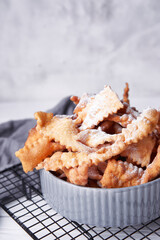 Brushwood - russian traditional cookies with powdered sugar. Food consept. Plate with hvorost on white marble background, Copyspace for text and design elements