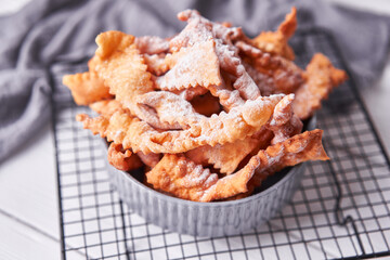 Brushwood - russian traditional cookies with powdered sugar. Food consept. Plate with hvorost on white marble background, Copyspace for text and design elements. Close up view