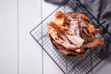 Brushwood - russian traditional cookies with powdered sugar. Food consept. Plate with hvorost on white marble background, Copyspace for text and design elements