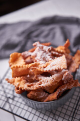 Brushwood - russian traditional cookies with powdered sugar. Food consept. Plate with hvorost on white marble background, Copyspace for text and design elements. Close up top view