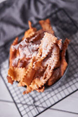 Brushwood - russian traditional cookies with powdered sugar. Food consept. Plate with hvorost on white marble background, Copyspace for text and design elements. Close up top view