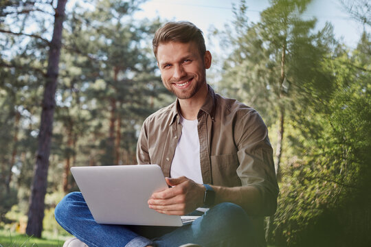 Optimitic bristled man with a notebook in nature - Powered by Adobe