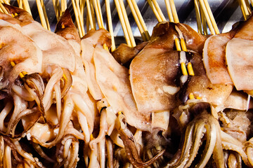 A pile of raw squids on wood stick