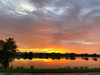 Beautiful pink, orange and blue sunset reflecting on a lake in a suburban