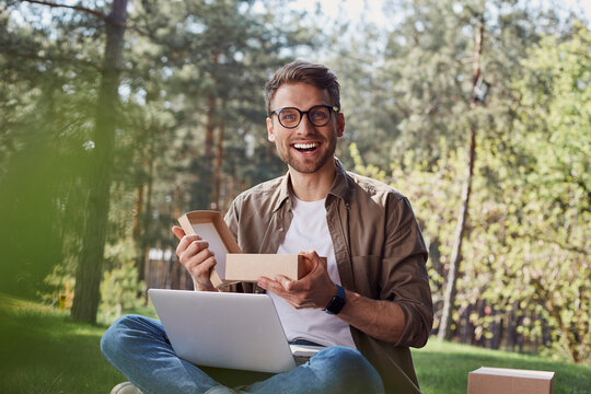Surprised smiling man with unpacked carton box