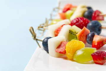 Fruit canapes. Fresh fruit canapes on white plate. Mixed fruit in white plate healthy food style, blue backgrounds.