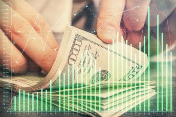 Multi exposure of forex graph drawing hologram and USA dollars bills and man hands. Technical Analysis concept.