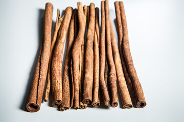 top view on big group of dry cinnamon sticks served on white table surface